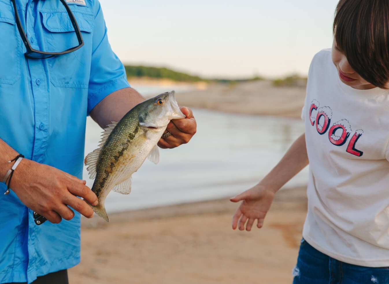A child getting a close look at a freshly caught fish